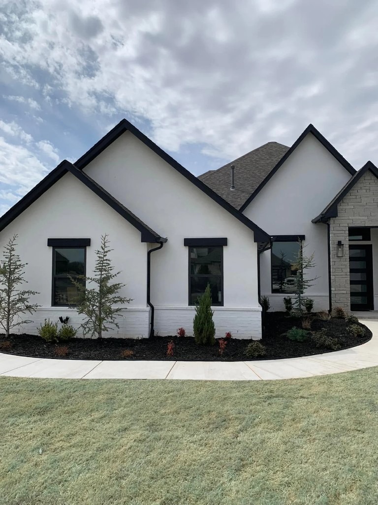 Modern home landscaping with mulch beds, evergreens, and a curved walkway in Newcastle, OK