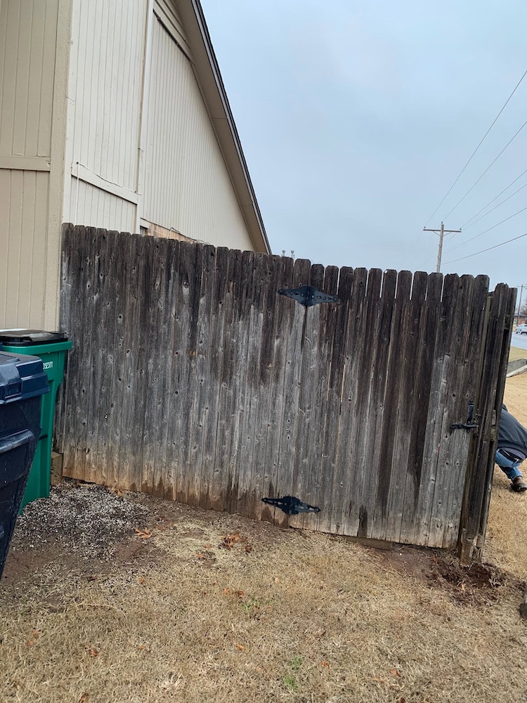 Before — Aging gray fence panels along a residential yard in Newcastle, OK
